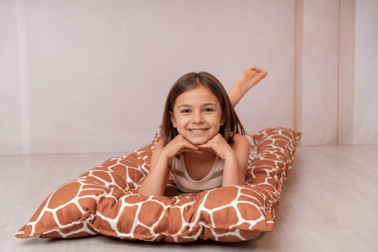 Child on giraffe print floor cushion